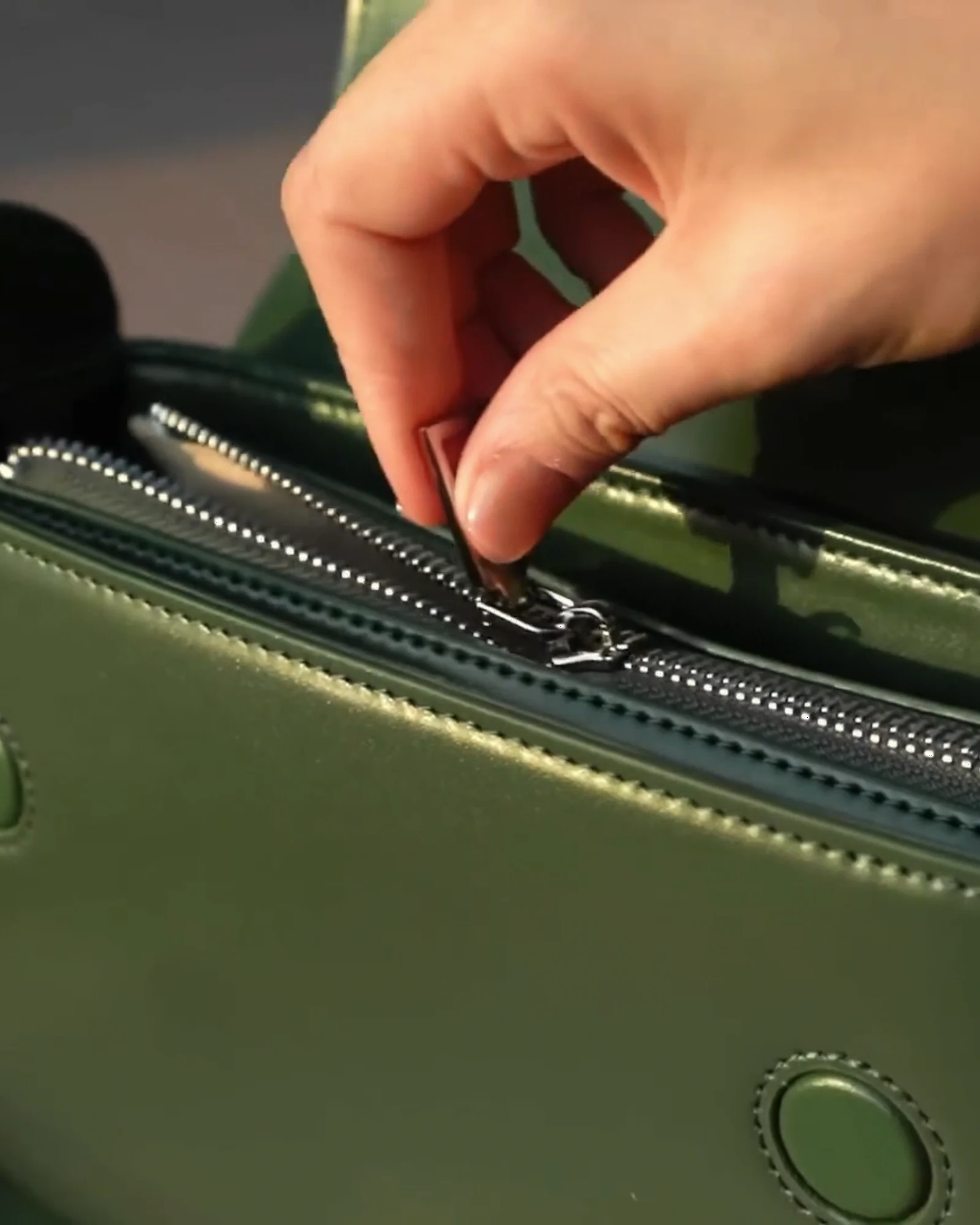 An MH Zipper zipper applied to a green leather bag
